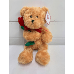 Tan teddy bear holding a red fabric rose with a tag on its ear