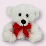White teddy bear with a red bow on a pale pink background