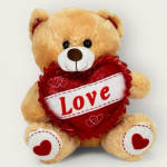 Tan teddy bear holding a red heart with the word Love
