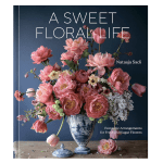Pink floral arrangement in a blue-and-white vase on a wooden table