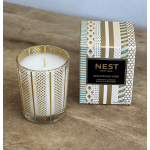 Scented candle in a patterned glass holder beside its box
