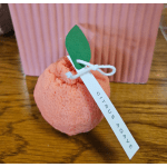 Pink citrus-shaped bath bomb with a green paper leaf and tag