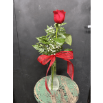 Single red rose in a clear glass vase with a red ribbon