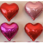 Four heart-shaped foil balloons in red, pink, and purple