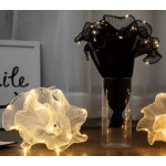 Black bouquet in a clear vase with glowing flower lights