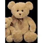 Two plush teddy bears with brown bows on a black background