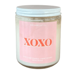 Pink-labeled soy candle in a glass jar with a silver lid