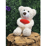 White teddy bear holding a red heart on a green backdrop with a purple rose