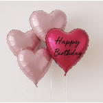 Heart-shaped pink balloons, one reading Happy Birthday