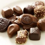 Assorted chocolate truffles and pralines on a light surface