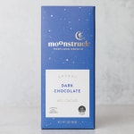 Blue box of dark chocolate bar standing upright on a light gray surface
