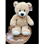 Plush teddy bear with a ribbon bow sitting on a wooden base