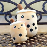 Two plush bubble tea toys with smiling faces and black tapioca dots