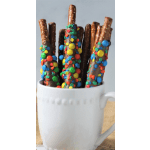 Chocolate-covered pretzel rods in a white mug