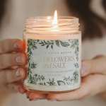 Lit candle in a glass jar with a floral label