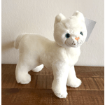 White plush cat figurine standing on a wooden surface