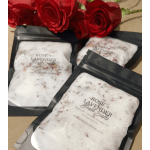 Rose and lavender bath salts packets with red roses in the background