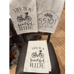 Folded white towels with black bicycle and text designs