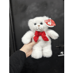 White teddy bear with a red bow being held in one hand