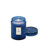 Blue glass candle jar with a lit wick and matching lid