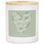 White candle in a glass jar with a wooden lid and heart-shaped label