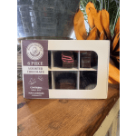 Box of assorted chocolates with orange decorative flowers behind it