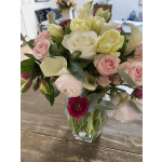 Mixed bouquet of pink, white, and yellow flowers in a clear glass vase