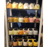 Shelves of large jar candles in assorted colors and scents