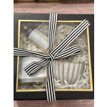 Gift box with a striped ribbon and assorted candles inside