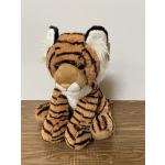 Plush tiger stuffed animal sitting on a wooden surface