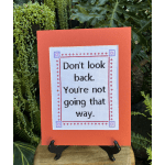 Orange card with a stitched quote displayed on a stand