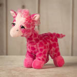 Pink plush giraffe toy with a bow on its head