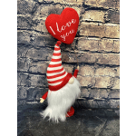 A small gnome figurine holds a red heart balloon that says "I love you."