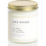 Cream candle in a glass jar with a gold lid and label