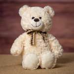 Cream teddy bear with a plaid ribbon bow