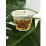 Container of creamed honey on large green leaves