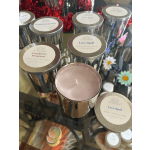 Assorted scented candles in metallic tins with floral accents
