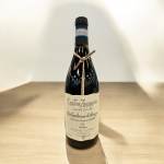 A bottle of red wine standing on a wooden surface