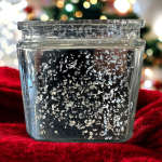 Decorative glass jar with a silver-speckled finish on red fabric