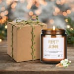 Amber glass jasmine candle with kraft gift box tied in twine on a rustic wood surface