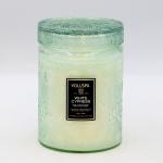 Green glass jar candle with a lid and label