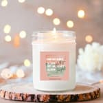 White scented candle in a glass jar with a printed label