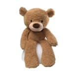 Brown teddy bear sitting on a white seat