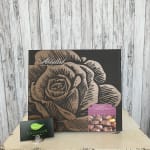 Box of milk chocolates with a rose design and a florist card