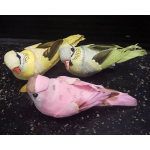 Three decorative bird figurines in pink, yellow, and green