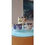 Three scented candles in glass jars with floral labels