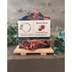 Two bars of black and pink rose soap on a small wooden stand
