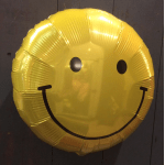 Yellow smiley-face balloon against a dark background