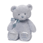 Light gray teddy bear with a blue ribbon and "my first teddy" on its foot