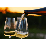 Wine being poured into a glass beside another filled wine glass